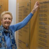 Linda pointing to the roll of honour where her late-husband is remembered