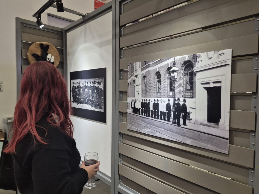 a young woman looks at photographs of police in the early 1900s
