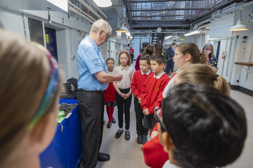 West Midlands Police Museum volunteer, James, shows items from the museums collection to primary school students.